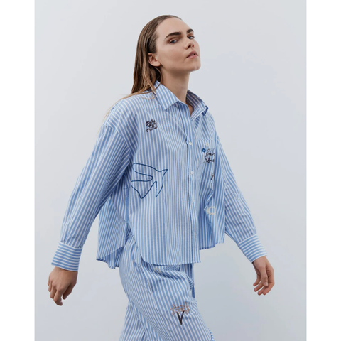 blue and white pinstripe collared shirt with embroidered pictures eg bird outline and 'beach vibes' on chest pocket 